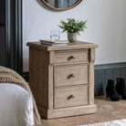 Vancouver 3 Drawer Bedside 520x450x650mm in a cozy bedroom setting with decorative items on top and boots near the wall.