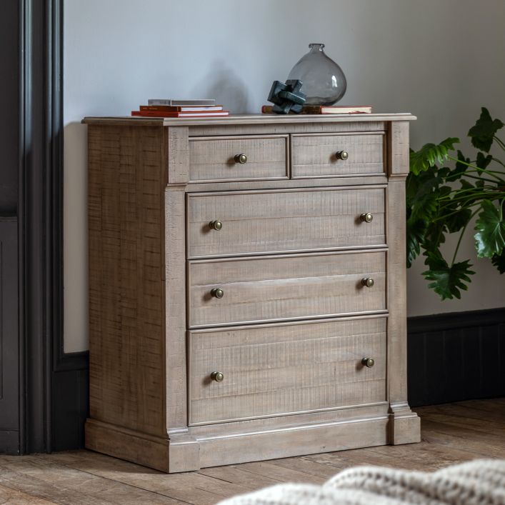 Vancouver 5 Drawer Chest 1130x485x1070mm in a light wood finish, styled in a room with decor items and plants.