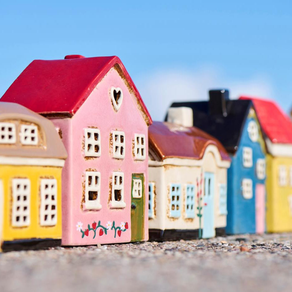 Colorful model houses arranged in a row with a clear blue sky.