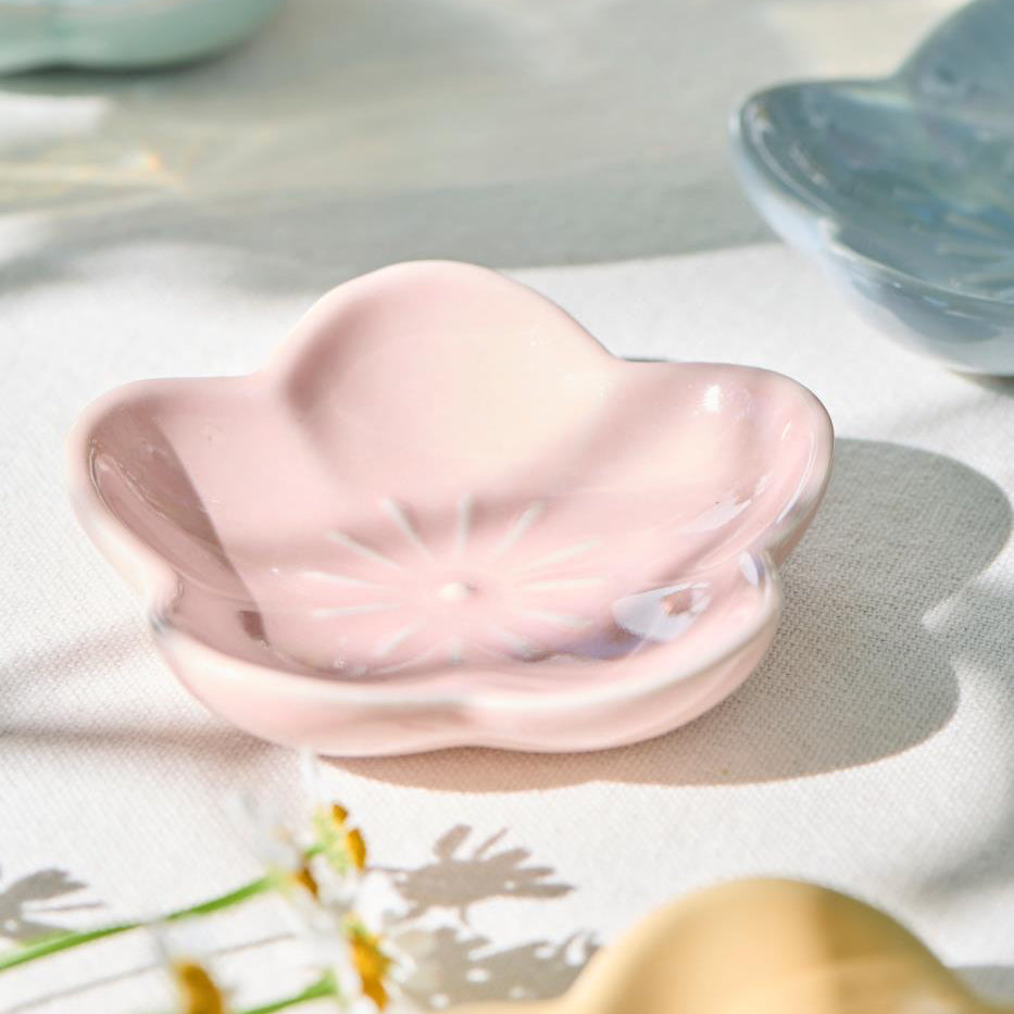 Pink ceramic dish on a textured surface with blurred background