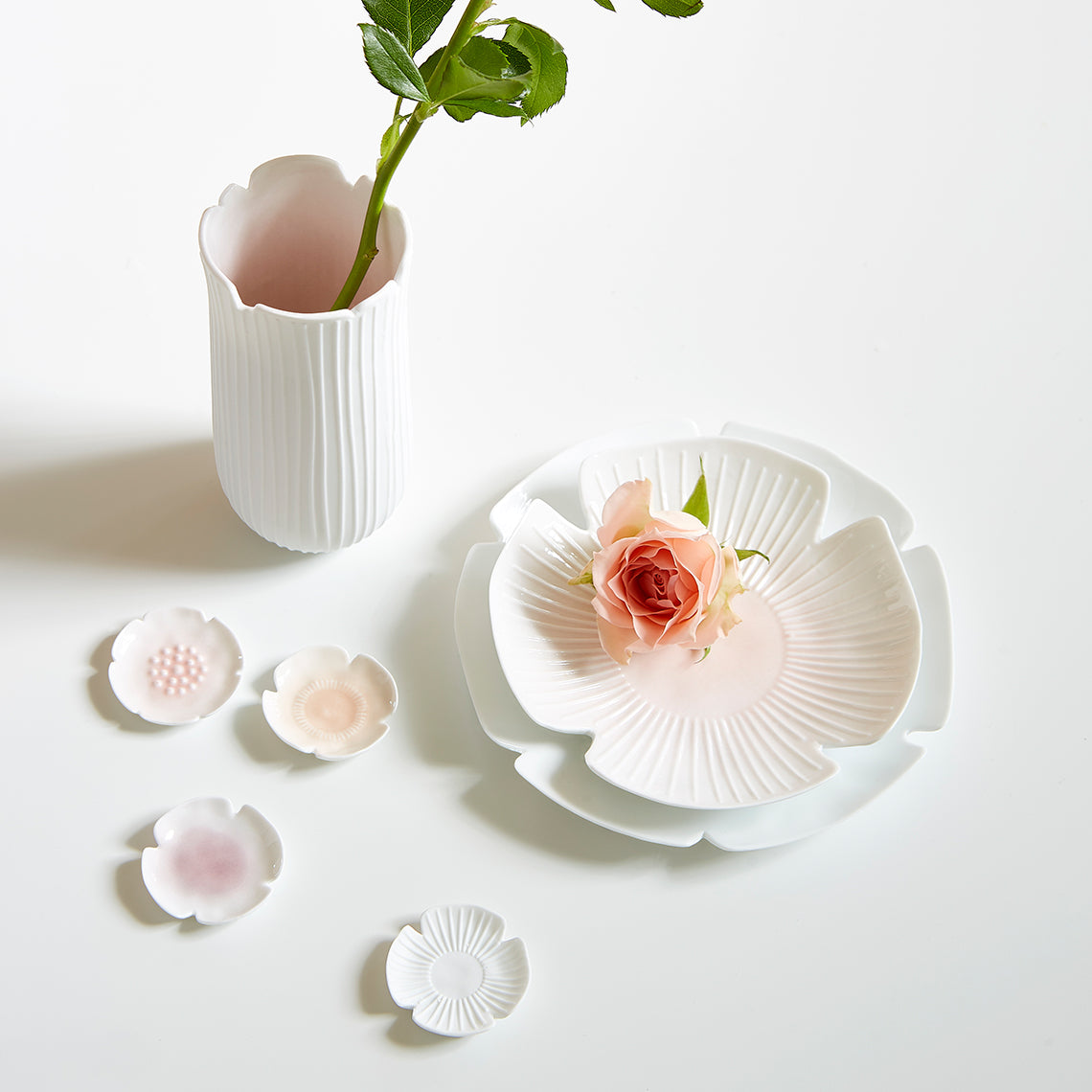 Set of white ceramic dishes with floral designs on a light background