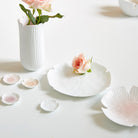 White ceramic tableware with flowers on a light background