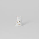 White ceramic cat-shaped object with gold accents on a light gray background