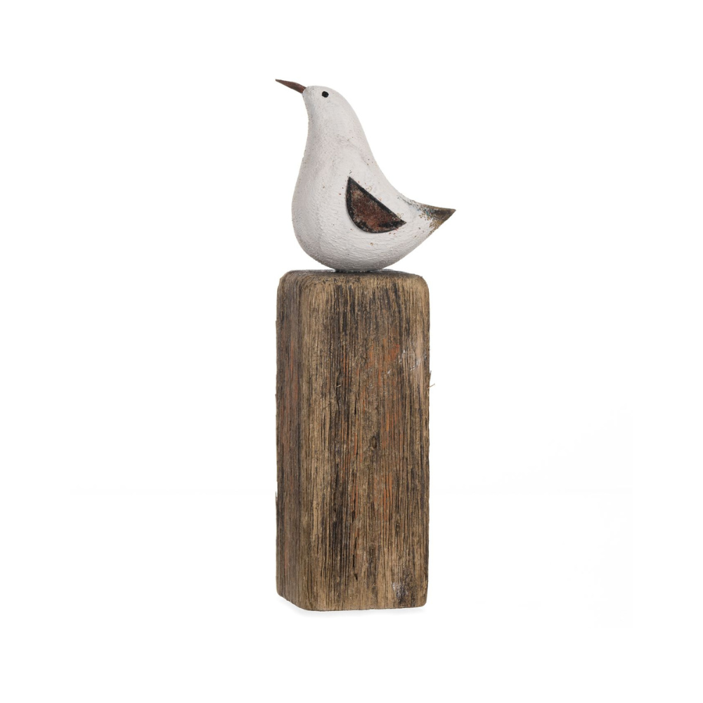 Decorative bird sculpture on a wooden block against a white background
