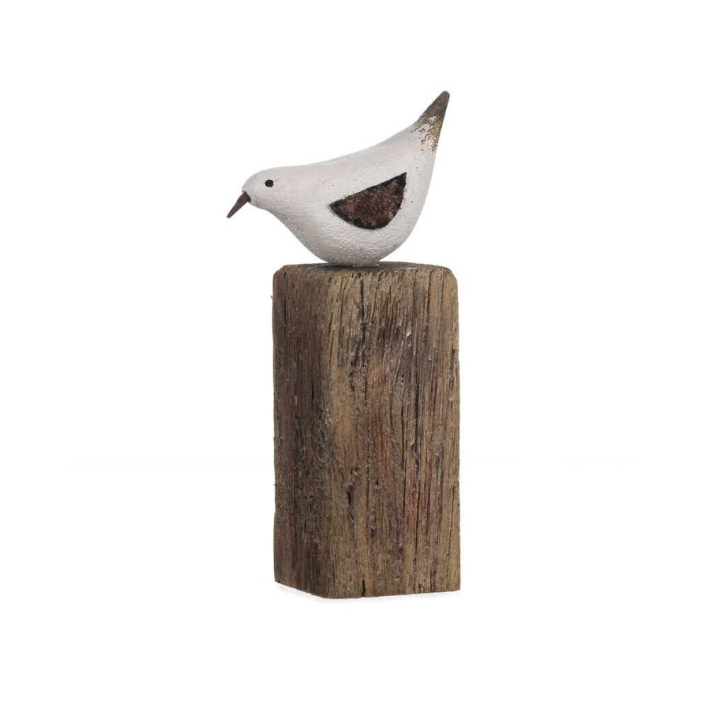 Decorative bird sculpture on a wooden block against a white background