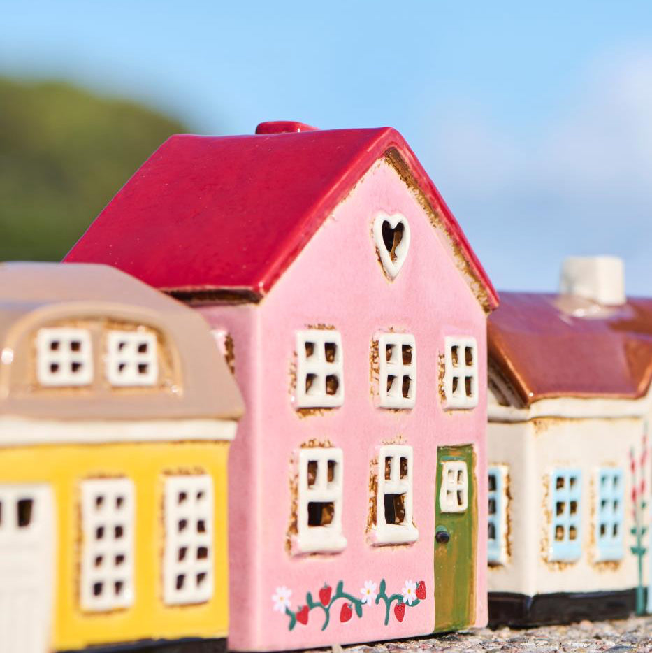 Colorful model houses with a pink house in the foreground on a blurred background