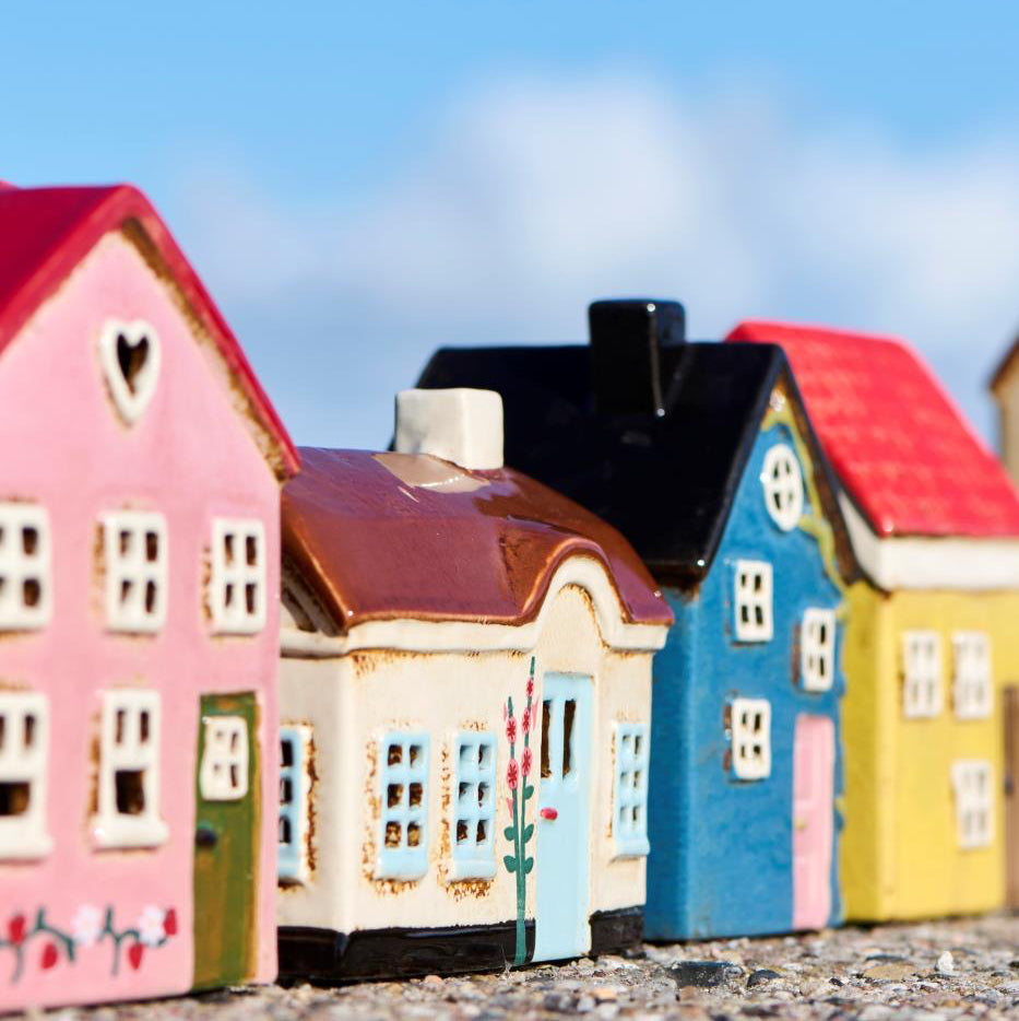 Colorful model houses arranged in a row with a clear blue sky.
