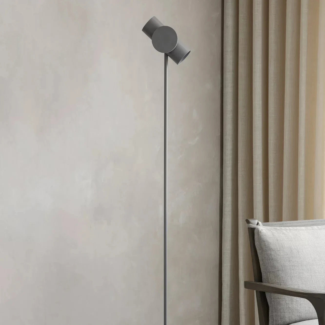 Modern floor lamp against a neutral wall with a chair in the background