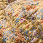 Close-up of a floral fabric with a yellow and multicolor pattern.