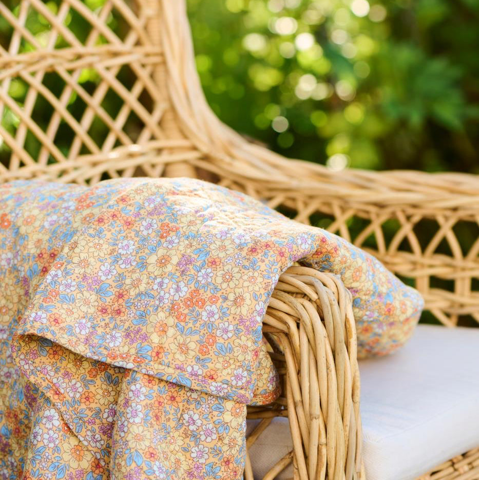 Wicker chair with a floral blanket in an outdoor setting