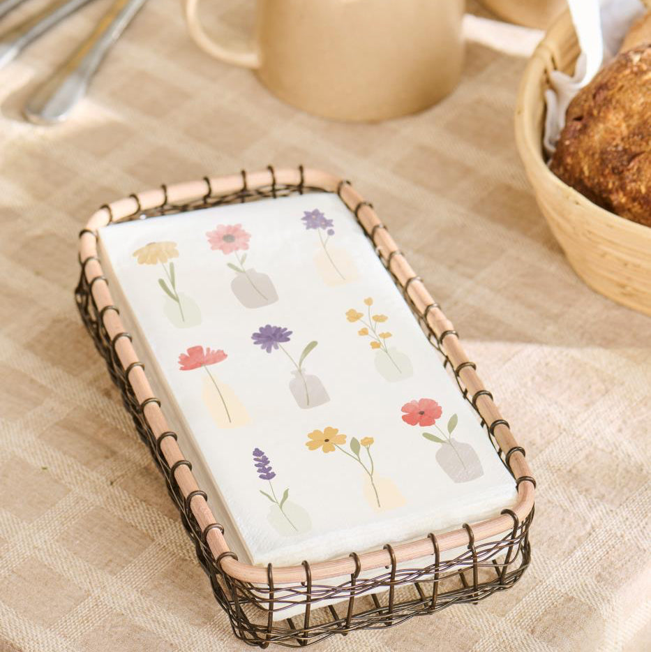 Phone case with floral design in a wire basket on a table with coffee and bread.
