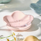 Pink ceramic dish on a textured surface with blurred background