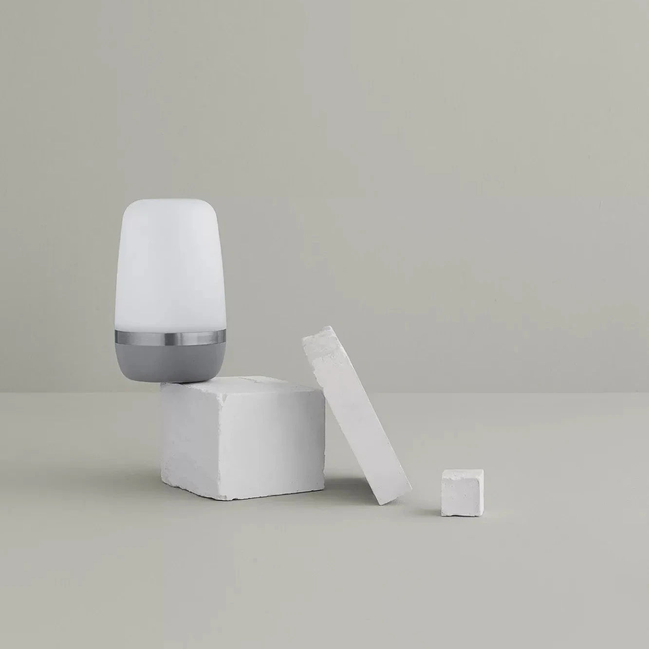 White cylindrical object with a gray base on a light gray background