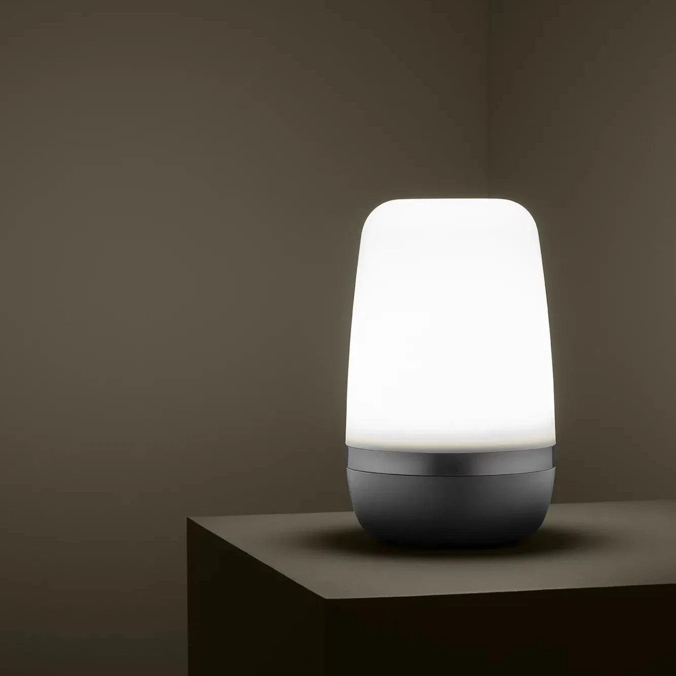 White lamp on a dark brown surface with a dark brown background