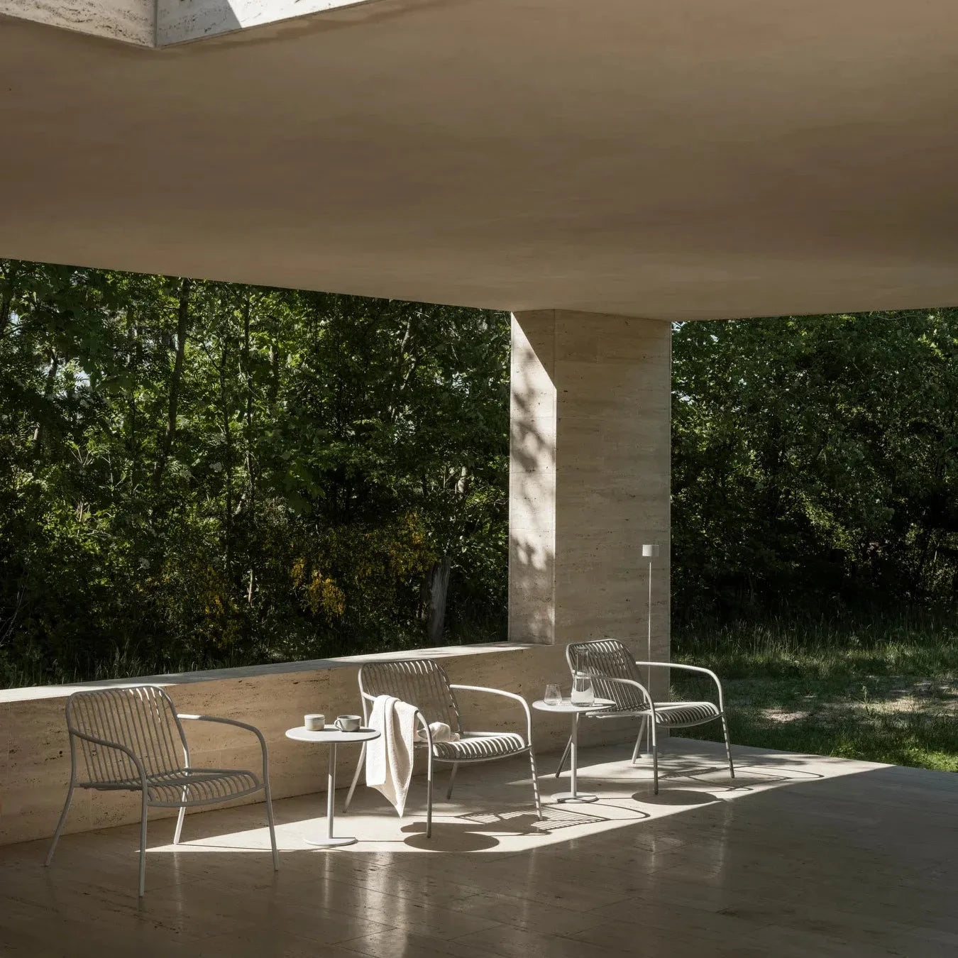Modern outdoor seating area with concrete structure and trees in the background