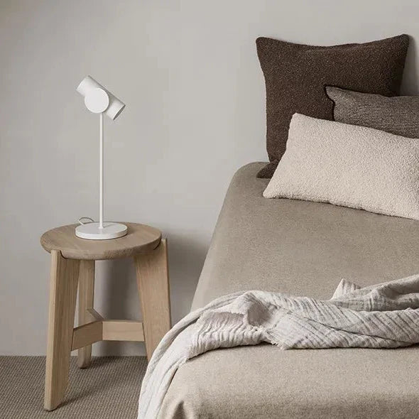 Neatly made bed with pillows and a blanket in a bedroom setting.